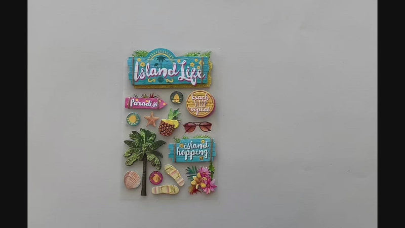 Female hands pick up ad show in detail 3D scrapbook stickers featuring photo real palm trees, flip flops , and florals with gold details.