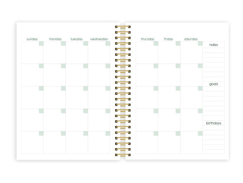 weekly planner featuring a monthly spread with gold coil spine, shown on white background.