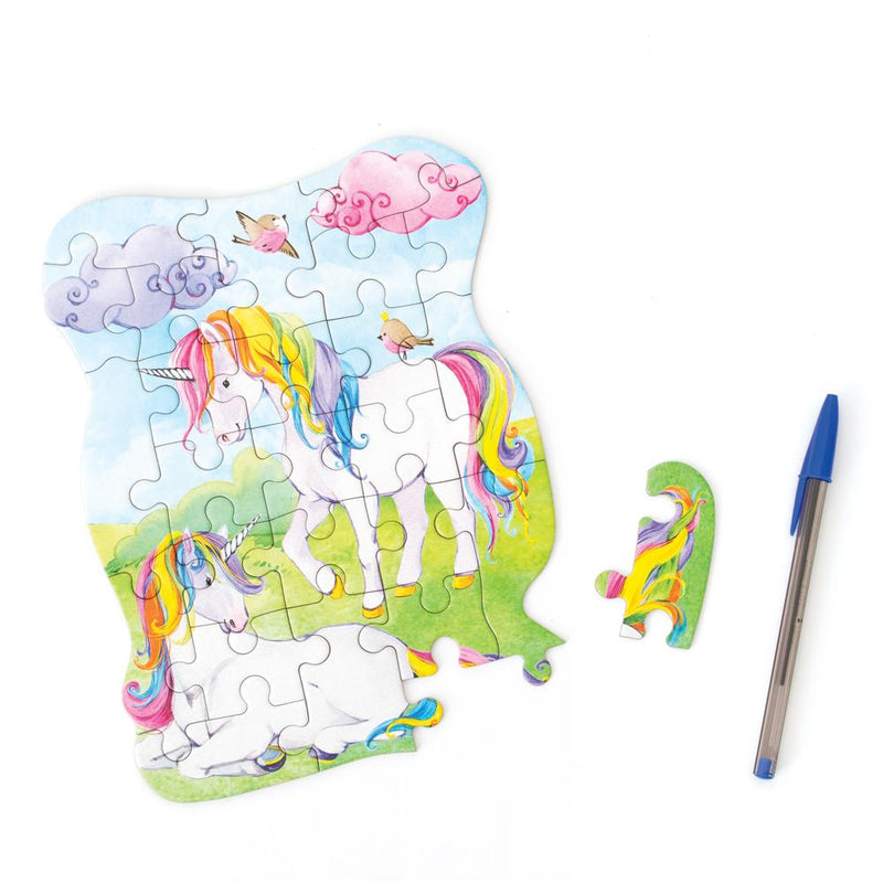 die cut mini jigsaw puzzle featuring illustrated pastel unicorns, shown with pen and one separate piece on white background.