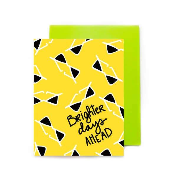note card featuring a black and yellow sunglass pattern overlapping a green envelope, shown on a white background.