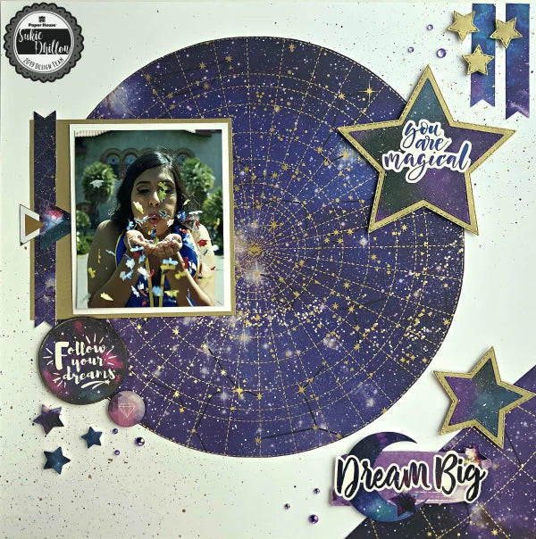 celestial themed scrapbook layout featuring a large circle cut from dark purple star galaxy scrapbook paper. Page features a photo of a woman and is embellished with purple and gold stars and stickers 