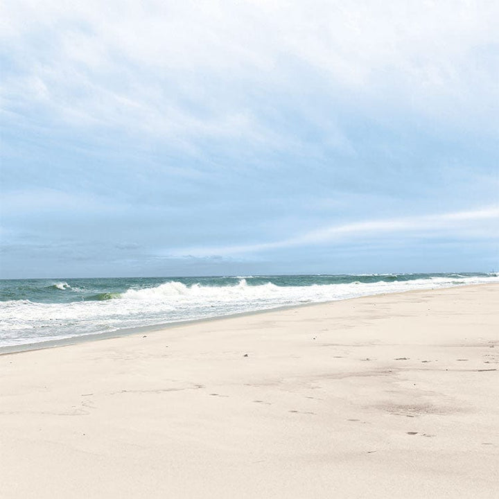 scrapbook paper featuring a photographic image of a beach with crashing waves.