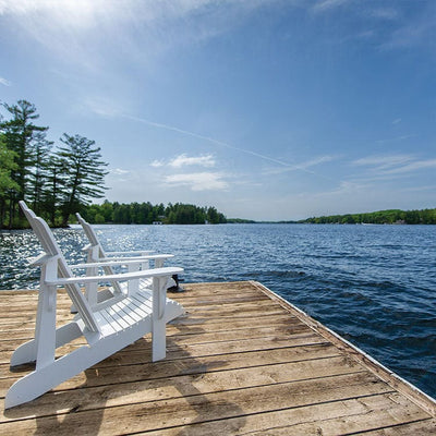 scrapbook paper featuring a photographic image of 2 white adirondack chairs on a wooden dock on a lake against a clear blue sky