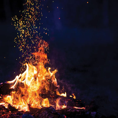 scrapbook paper featuring a photographic image of large fiery campfire against a black background.