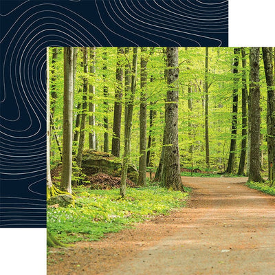 scrapbook paper featuring a photographic image of a path in the woods, shown overlapping a pattern of white wavy lines on a dark blue background.