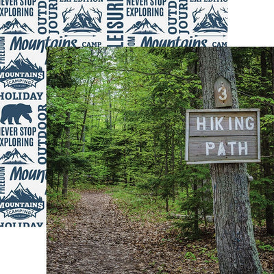 scrapbook paper featuring a photographic image of a tree in a green leafy forest with a Hiking Path sign attached to it shown overlapping a pattern of blue words and illustrations on white background.