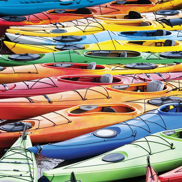 scrapbook paper featuring a photographic image of colorful kayaks