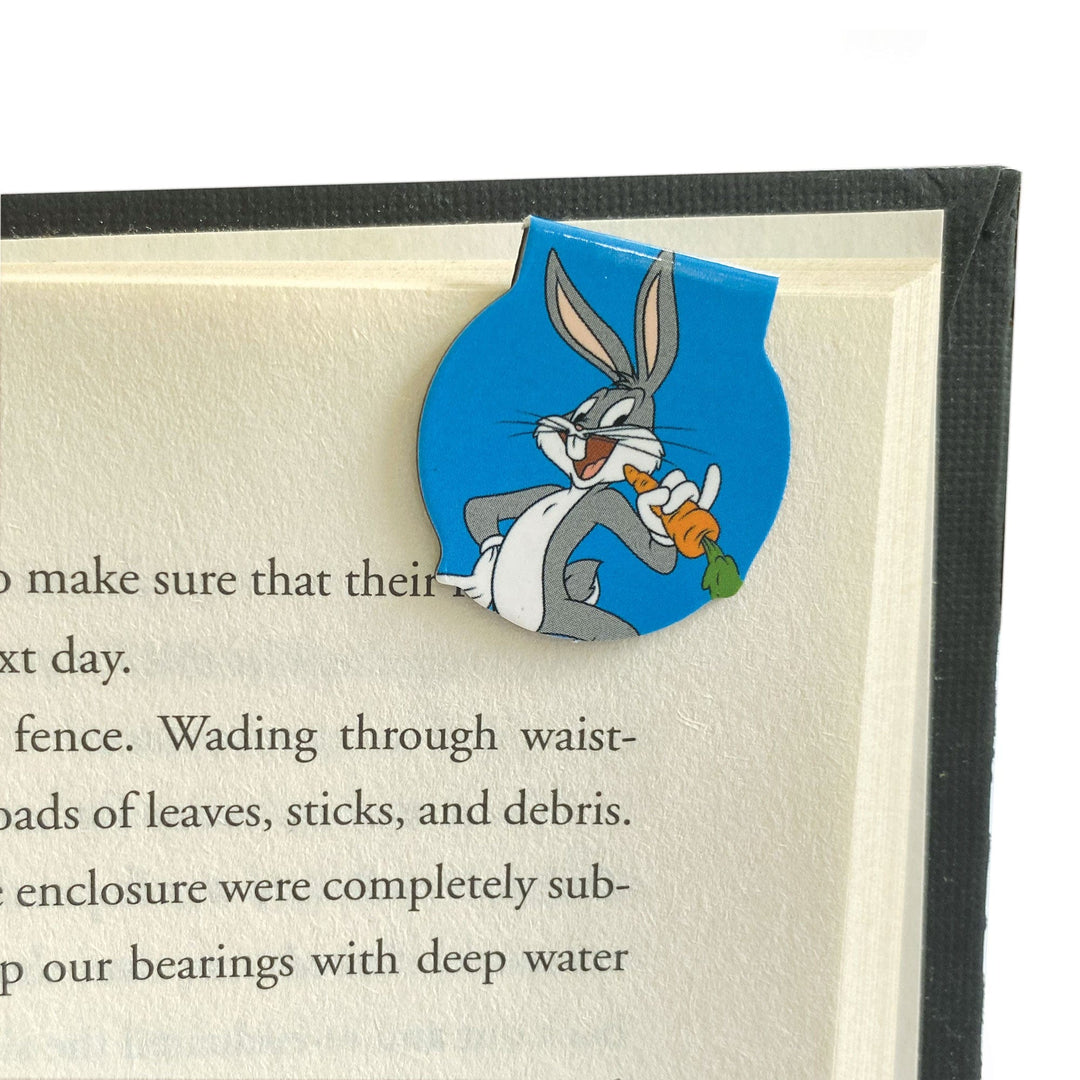 BMMG-0031E - Looney Tunes Magnetic Bookmarks - Bugs Bunny magnetic bookmark with blue circular background, holding a carrot, placed on an open book page