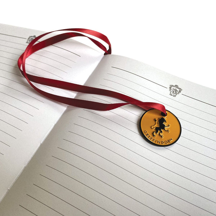 JL-0066E - Harry Potter Gryffindor Vegan Leather Journal - Open lined journal with red ribbon bookmark and gold circular Gryffindor medallion pendant on cover