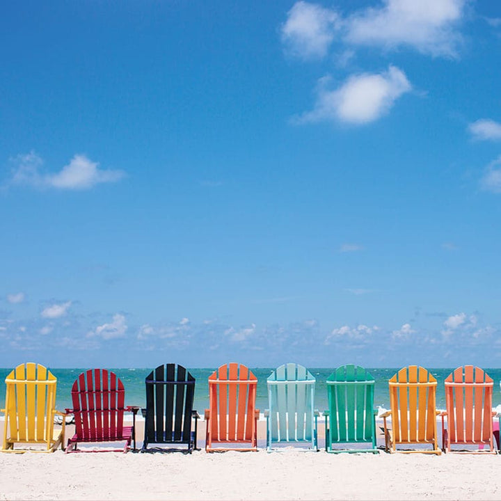 scrapbook paper featuring a photographic image of a row of colorful chairs along the beach.