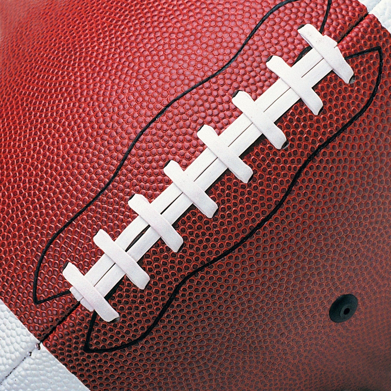 P-2406E - Football 12 x 12 Scrapbook Paper - Close-up of red football with white laces and black stitching detail