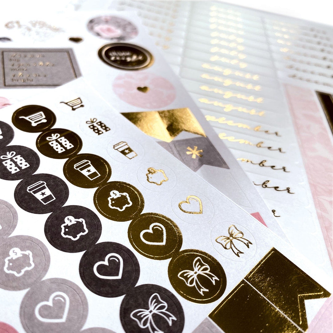 PL-2015E - Weekly Planner - Undated Soul Shine - Decorative sticker sheets featuring gold and black circular icons with hearts, bows, and gifts on white background with pink accents