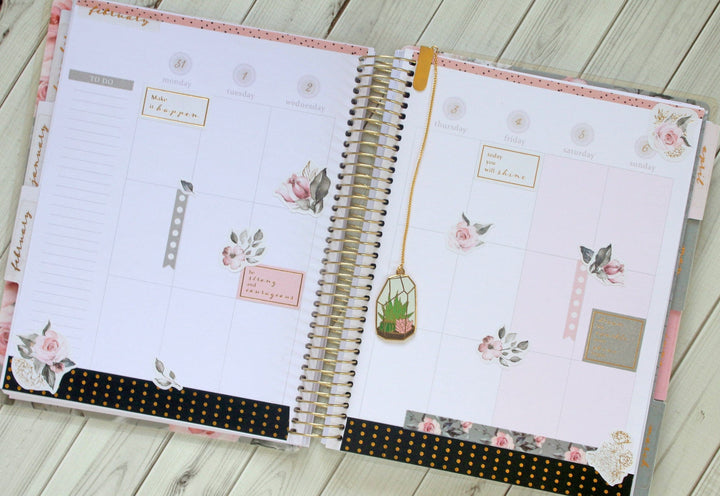 PL-2015E - Weekly Planner - Undated Soul Shine - Spiral-bound weekly planner with floral designs, gold accents, and motivational text on a wooden surface