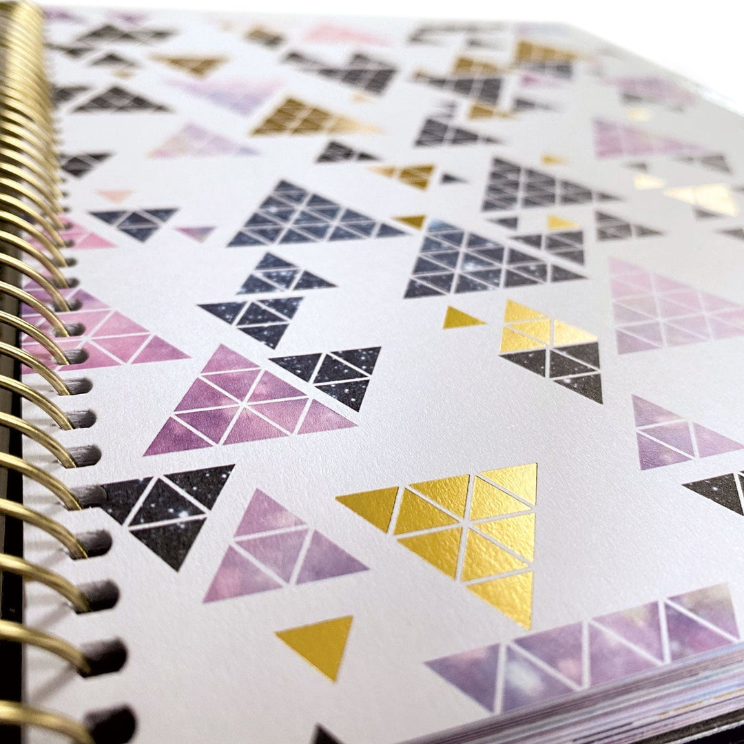 PL-2018E - Weekly Planner - Undated Stargazer - Spiral-bound planner page featuring colorful geometric triangle stickers in pink, gold, and black arranged in decorative patterns