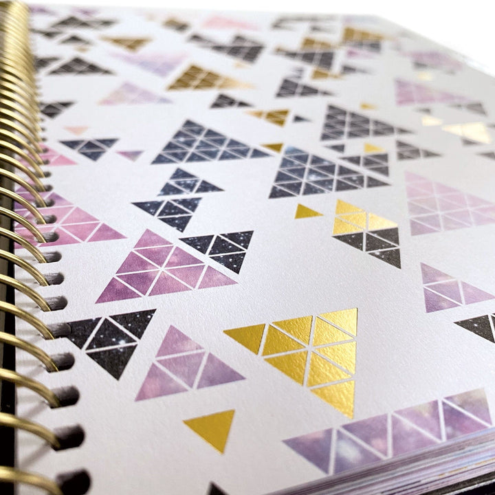PL-2018E - Weekly Planner - Undated Stargazer - Spiral-bound planner page featuring colorful geometric triangle stickers in pink, gold, and black arranged in decorative patterns