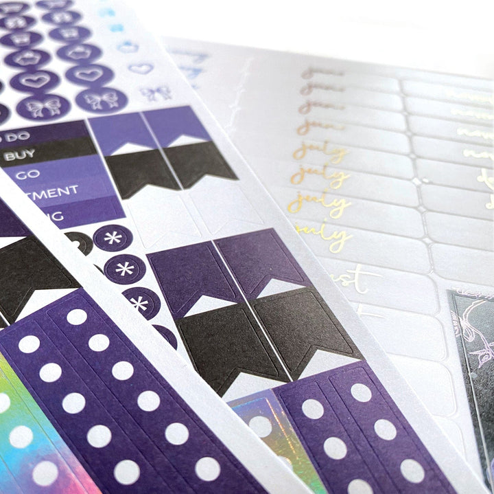 PL-2021E - Weekly Planner - Sun &amp; Moon Celestial - Purple and black celestial-themed planner pages with decorative stickers, tabs, and gold script text