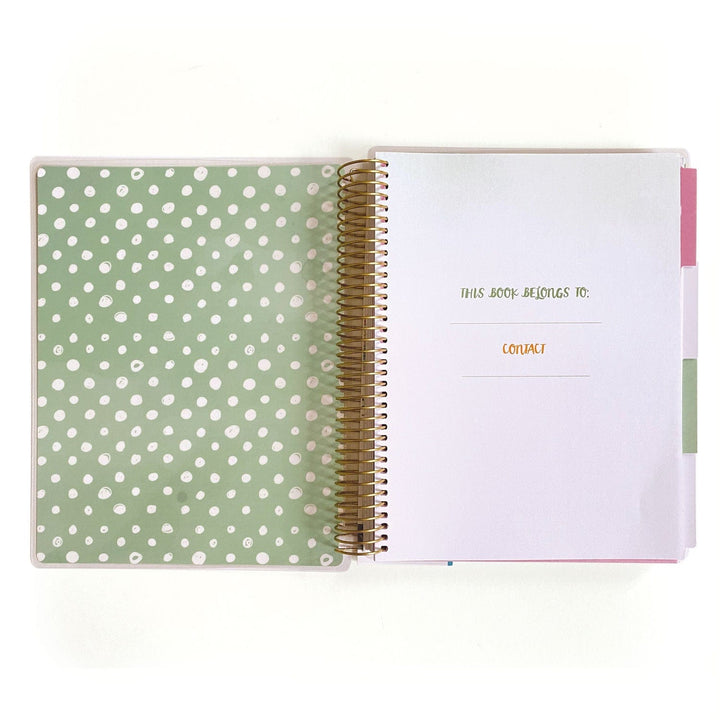 PL-2023E - Weekly Planner - Boho Rainbow - Spiral-bound planner open to ownership page with green polka dot cover and gold spiral binding visible