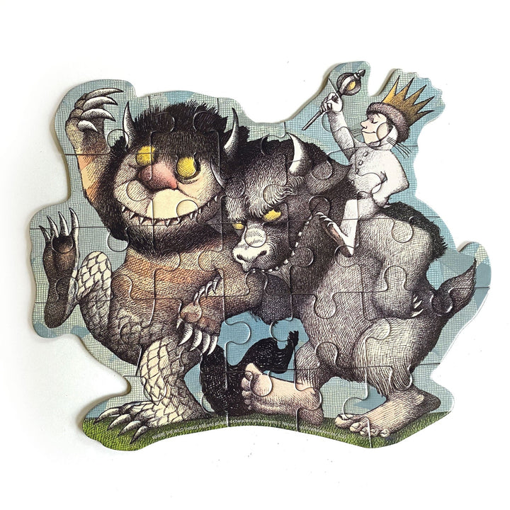 PUZ-7022E - Mini Jigsaw Puzzle - Where The Wild Things Are - Shaped puzzle featuring illustrated wild creatures with horns and a crowned child character against a light blue background