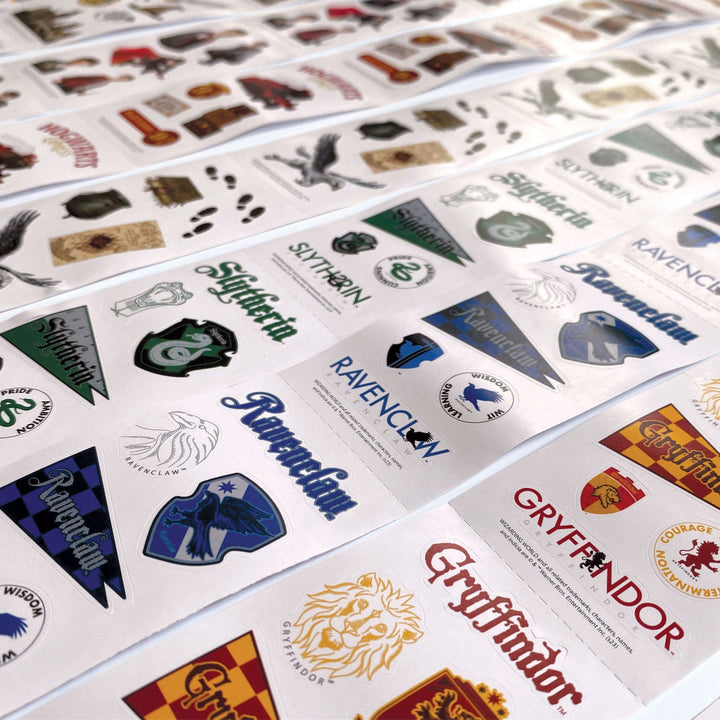 STRSET-0001E - Harry Potter Sticker Roll Box Set - Multiple sticker sheets displaying Harry Potter house crests, logos, and symbols in green, blue, red, and gold colors arranged in rows