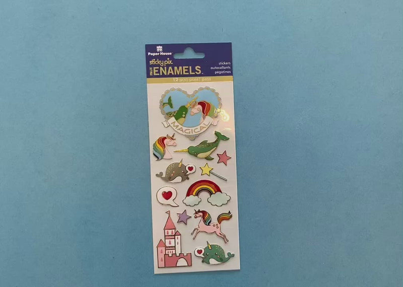 female hands display foil stickers featuring colorful illustrations of unicorns, rainbows and narwhals with gold details, and shows close up of one individual sticker.
