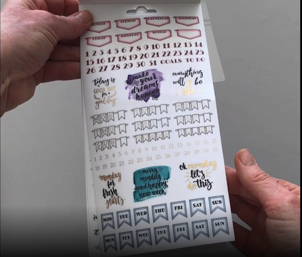 Female hands pick up and flip through the pages of the "Creative-Weekly" planner stickers booklet to show each page of stickers in detail. There are four pages in this sticker book by Paper House Productions.