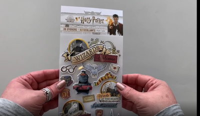 Female hands pick up and show front and back of 3D scrapbook stickers and package featuring Harry Potter.