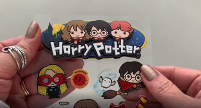 3D scrapbook stickers being shown in hand, front and back in this video featuring Chibi Harry Potter characters.