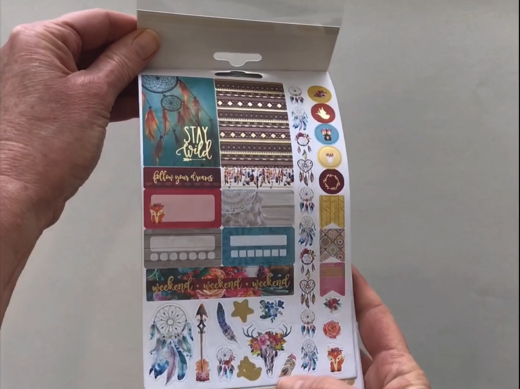 Female hands pick up and flip through the pages of the "Free Spirit" planner stickers booklet to show each page of stickers in detail. There are four pages in this sticker book by Paper House Productions.