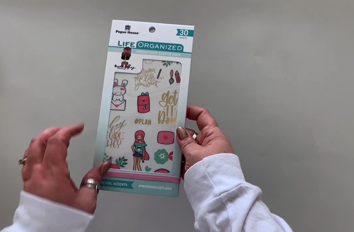 Female hands pick up and flip through the pages of the "Mommy Lhey" planner stickers booklet to show each page of stickers in detail. There are thirty pages in this sticker book by Paper House Productions.
