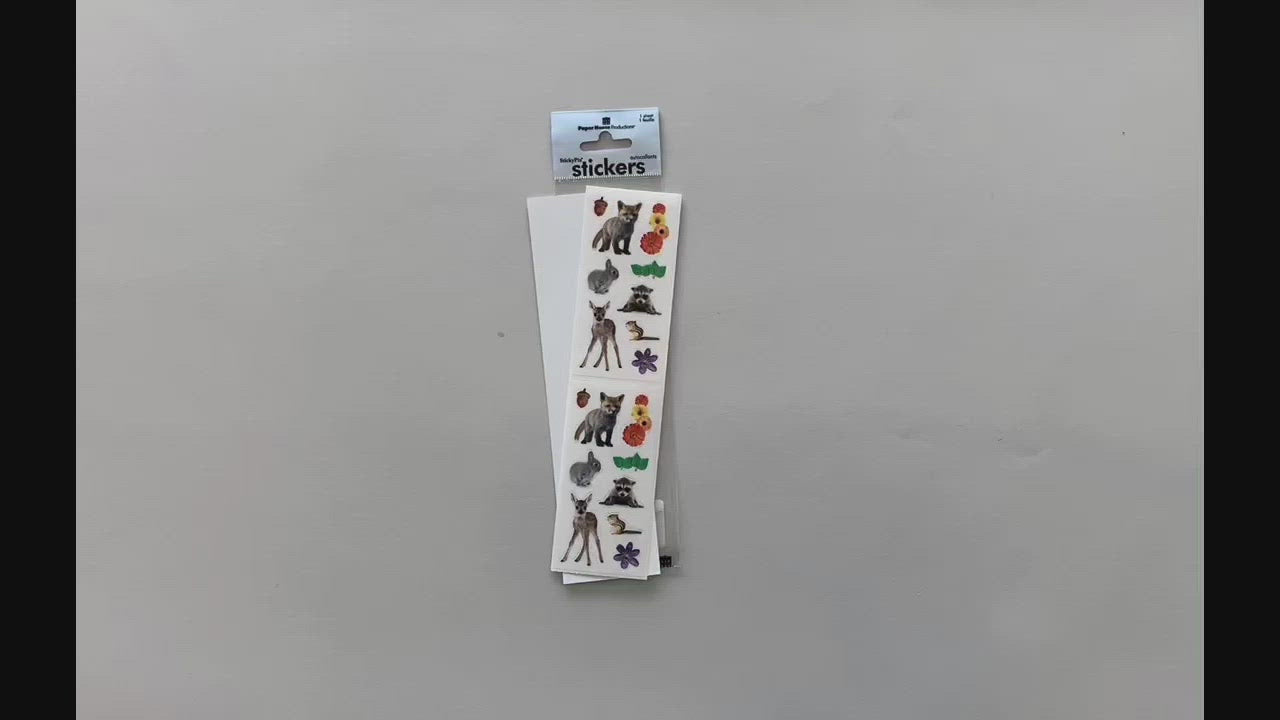Female hands pick up and show stickers featuring photo real backyard animals and flowers in detail.