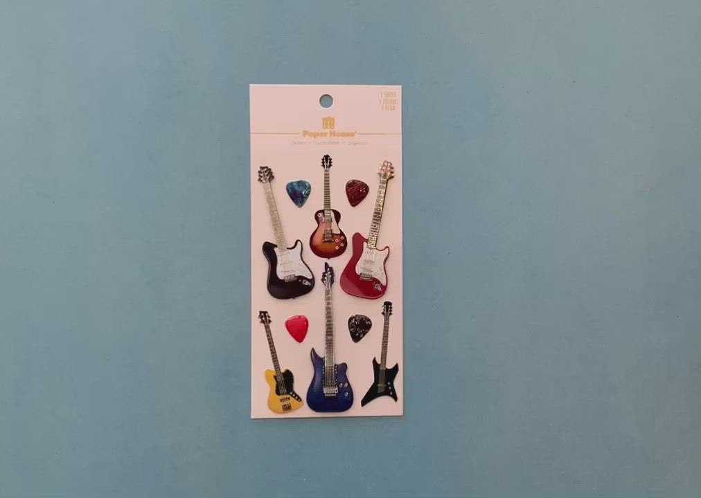 female hands display  scrapbook stickers featuring colorful electric guitars, and shows close up of 2 individual stickers.