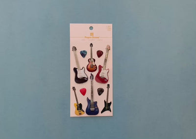 female hands display  scrapbook stickers featuring colorful electric guitars, and shows close up of 2 individual stickers.