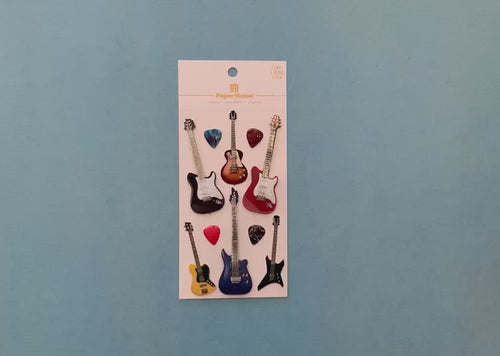 female hands display  scrapbook stickers featuring colorful electric guitars, and shows close up of 2 individual stickers.