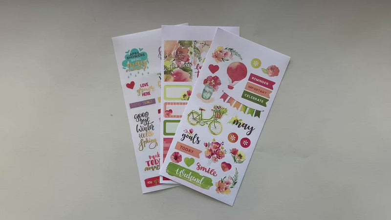 Female hands pick up and show in detail 3 planner sticker sheets featuring colorful florals.