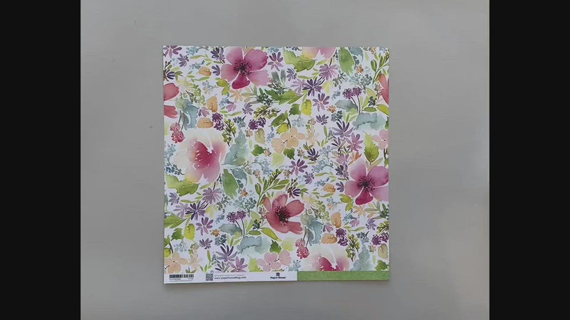 Female hands pick up and show front and reverse of this spring floral scrapbook paper.