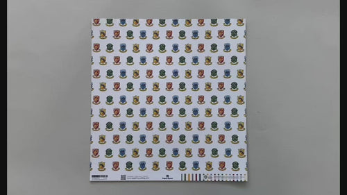 Female hands pick up harry potter scrapbook paper featuring a pattern of the multi-colored House Crests on one side and a pattern of colored stripes on the reverse.