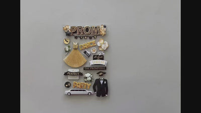 Female hands pick up and show front and back details of 3D scrapbook stickers featuring a gold prom dress, tuxedo and limo.