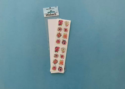 female hands display stickers featuring illustrated peach poppies, and shows a close up of one sticker in detail.