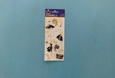female hands display sheet of  foil stickers featuring black and gold fashion illustrations and shows close up of one sticker.