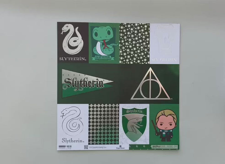 Female hands display Harry Potter scrapbook paper featuring Slytherin tags with silver details, and a green pattern of the Slytherin mascot on the reverse.