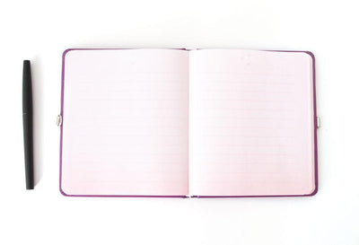 Unicorn locking diary shown open featuring light pink lined pages and a black pen.