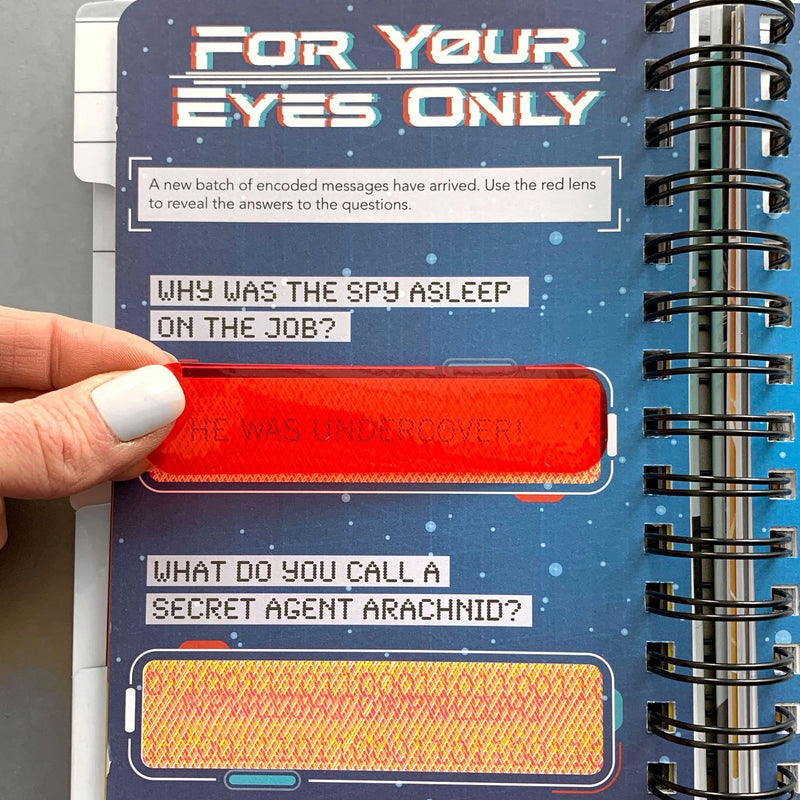 kids journal featuring a close up of FOR YOUR EYES ONLY page with hand showing red shape over words.