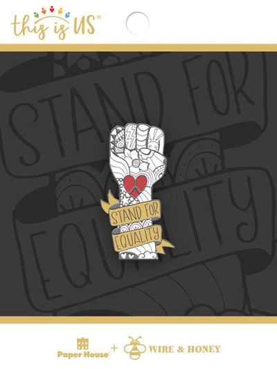 Stand for Equality enamel pin shown in packaging featuring a dark gray background with the enlarged Stand for Equality banner.