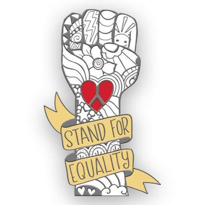 enamel pin shaped as a white clenched fist illustrated with silver line art and a red peace sign heart in the center. "Stand for Equality"  in silver letters on yellow banner wrapped around the wrist.