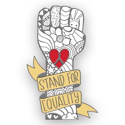 enamel pin shaped as a white clenched fist illustrated with silver line art and a red peace sign heart in the center. "Stand for Equality"  in silver letters on yellow banner wrapped around the wrist.