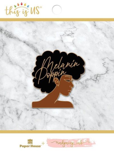 Melanin Poppin enamel pin shown in packaging against a gray marble background.