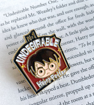Harry Potter enamel pin shown on a page of text from a Harry Potter novel.