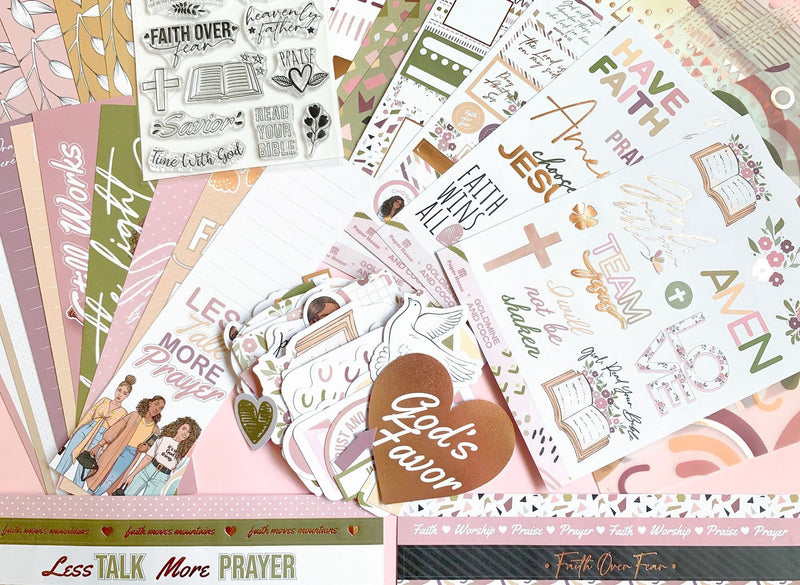 An assortment of items from this bible journaling craft kit are displayed featuring stickers, papers and stamps in soft, muted colors with gold details.