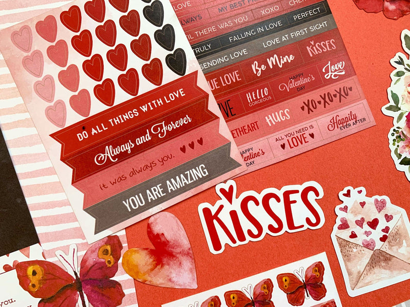 this craft kit image features a close up of red stickers of hearts, and words of love on a red background.