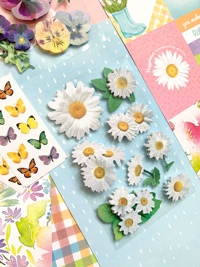 this craft kit image features close up of spring themed scrapbook papers and stickers on an angle.